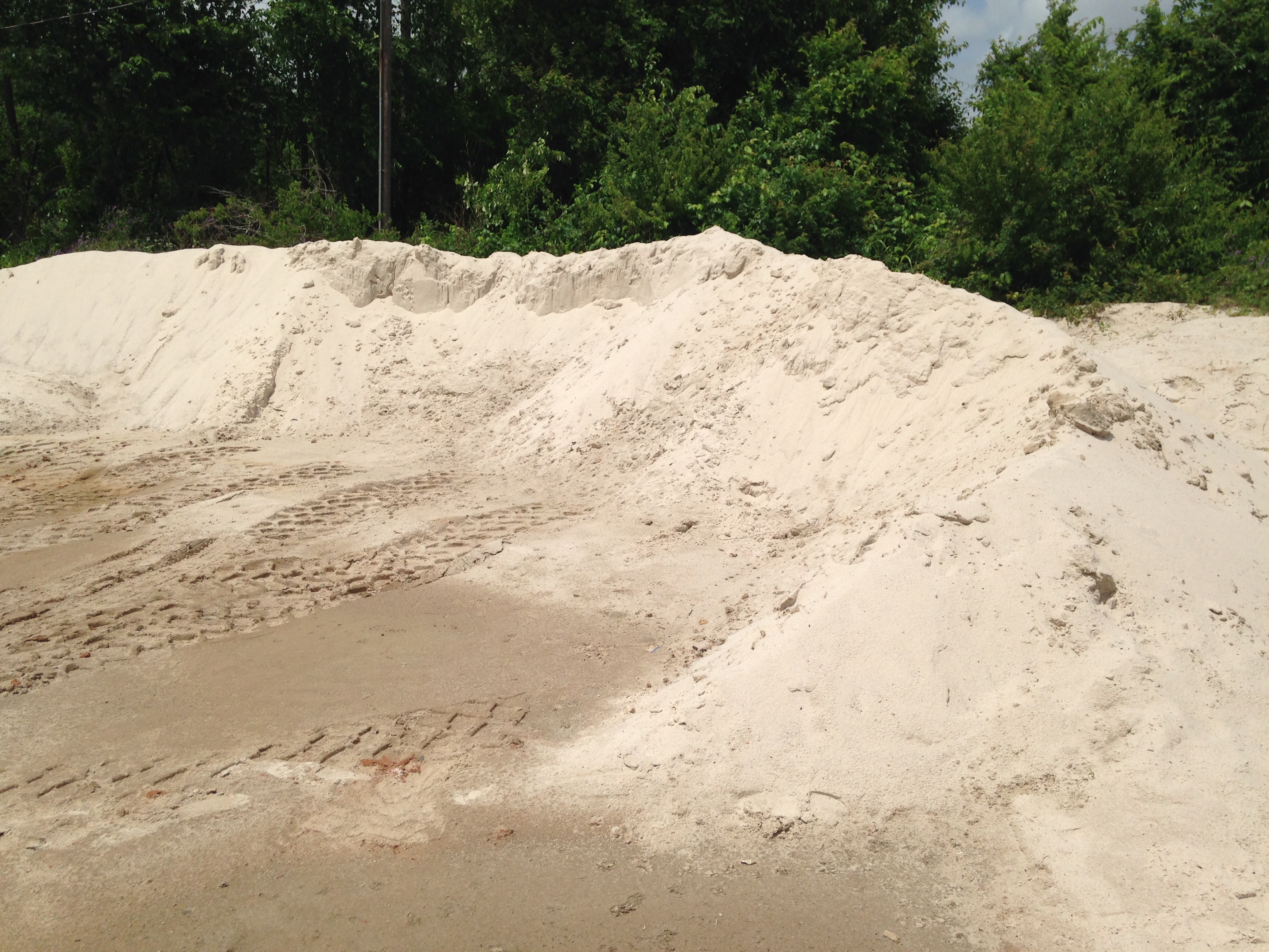A pile of sand stockpiled and ready for delivery at our yard