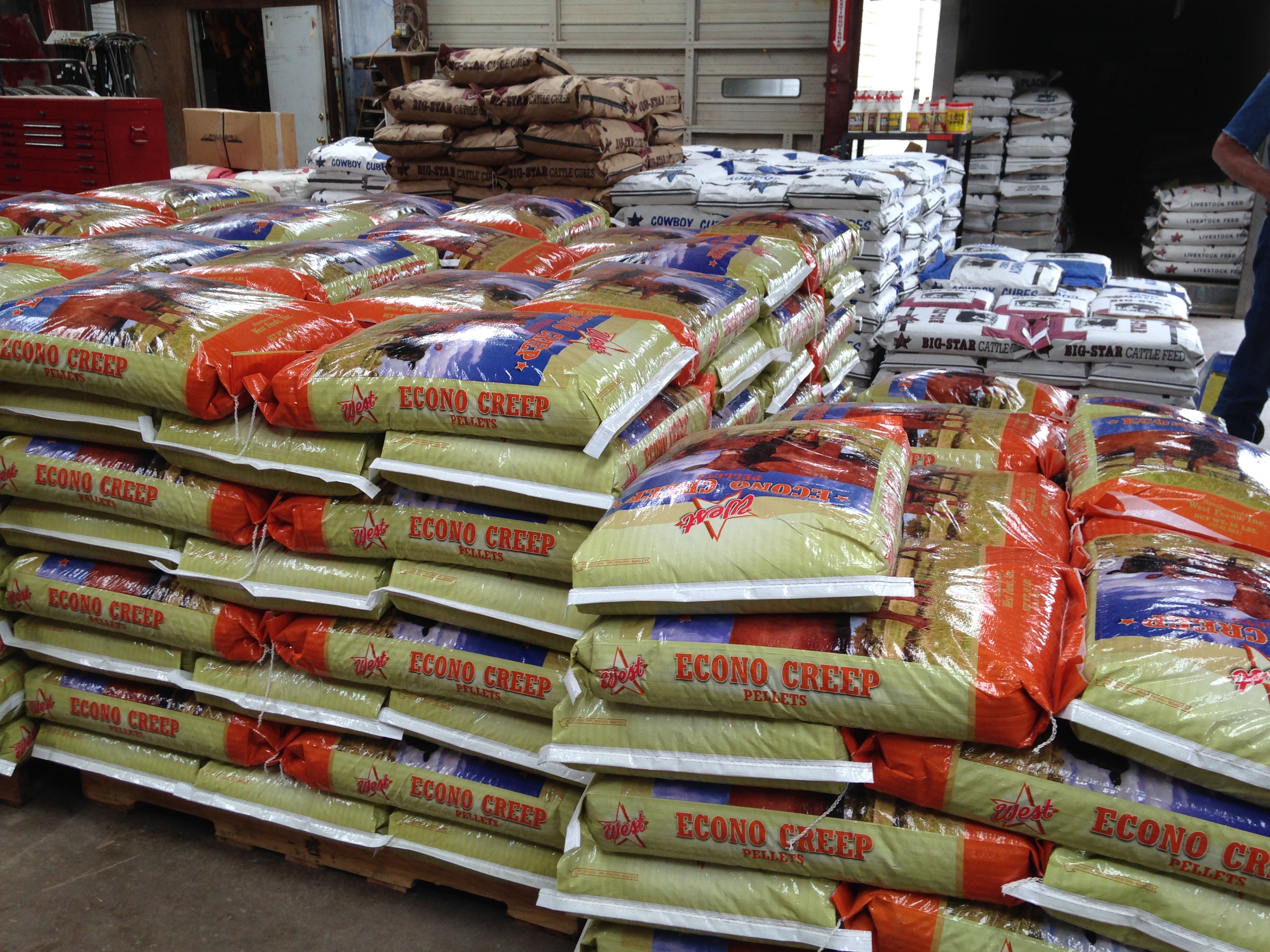 Pallets of cattle feed and cattle cubes stocked inside our store